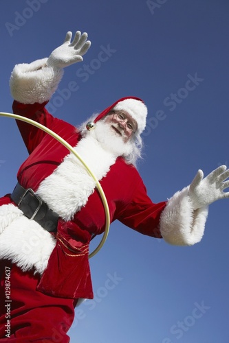 Low angle view of Santa Claus doing hula hoop against clear sky