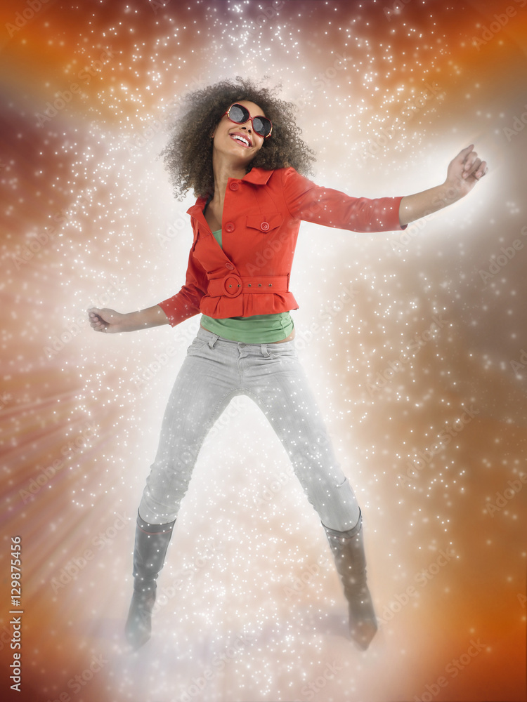 Full length of an Afro young woman dancing with lighting effect Full length of an Afro young woman dancing with lighting effect