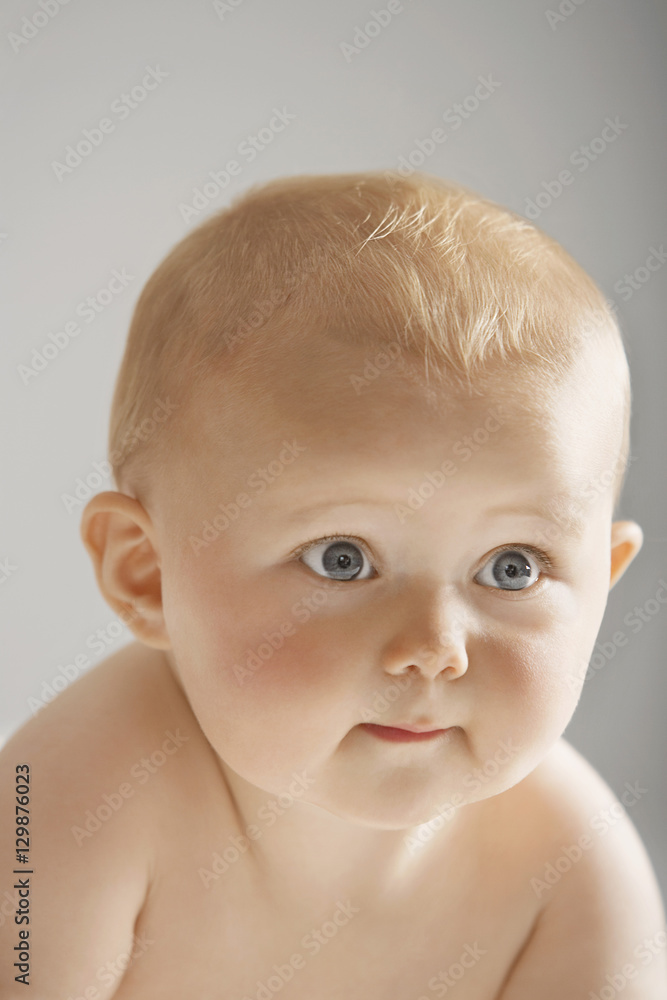 Closeup of cute baby looking away isolated on gray background Closeup of cute baby looking away isolated on gray background