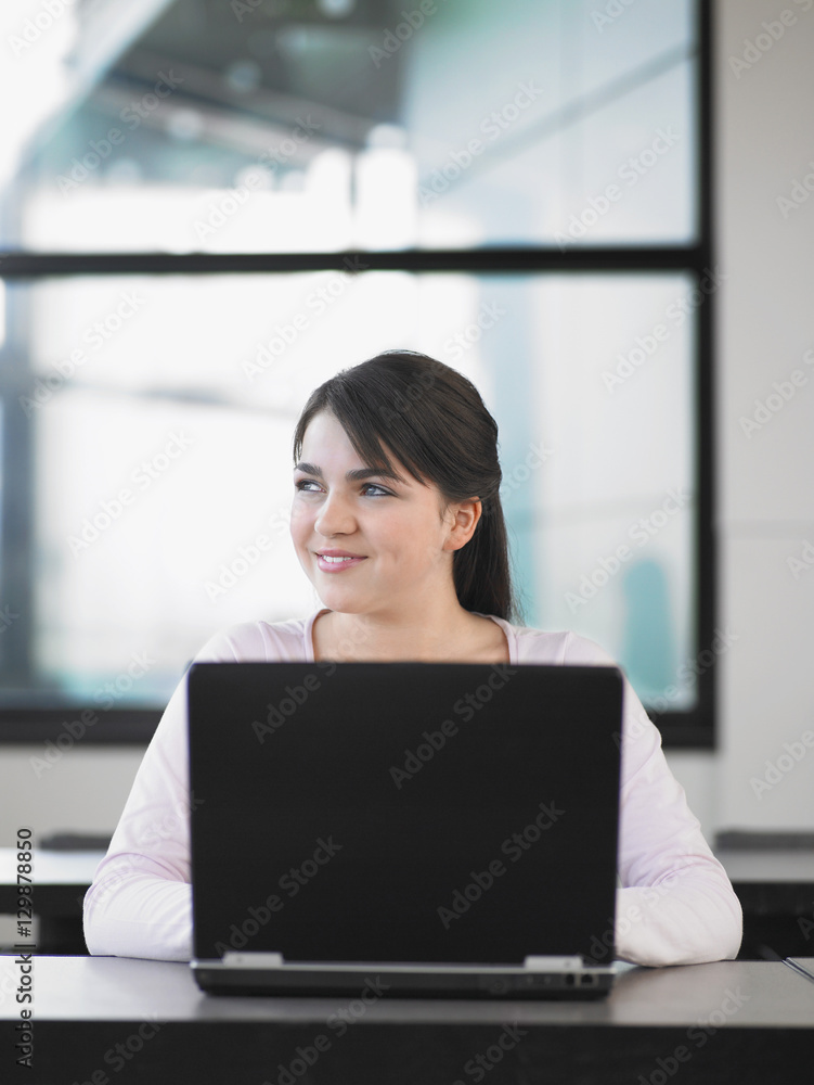 Young beautiful female with laptop looking away Young beautiful female with laptop looking away
