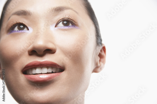 Closeup of beautiful Asian woman looking away on white background