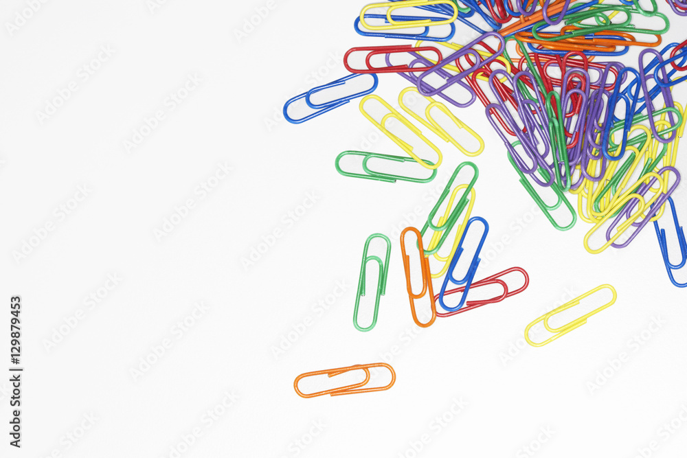 Scattered multicolored paper clips over white background Scattered multicolored paper clips over white background