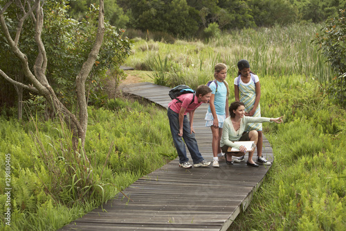 Teacher showing something to children during nature field trip