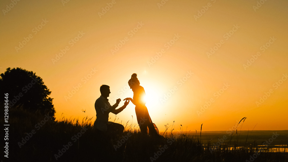 Couple - Man Getting Down on his Knee and Proposing to Woman high hill -  Gets Engaged at Sunset - Putting Ring Girl's Finger