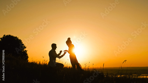 Couple - Man Getting Down on his Knee and Proposing to Woman high hill -  Gets Engaged at Sunset - Putting Ring Girl's Finger