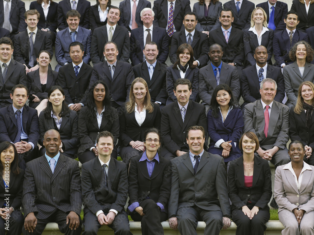 Group portrait of smiling multiethnic businesspeople sitting in a row