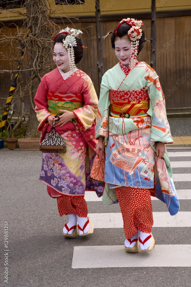 Maiko (apprentice geisha) walking in the streets of the Gion district  wearing traditional Japanese kimono and okobo (tall wooden shoes), Kyoto,  Kansai region, island of Honshu, Japan Stock Photo | Adobe Stock