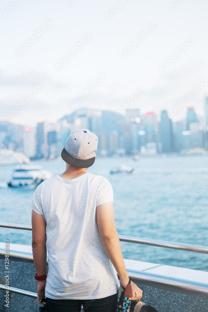 People with city background with sunset, Tsim Sha Tsui Promenade and Avenue of Stars in Victoria Harbour, Kowloon.