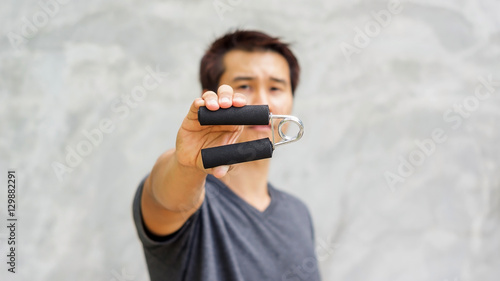 Obraz na plátně Man use handgrips for exercise.