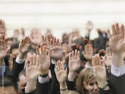 Closeup of business crowd raising hands photo