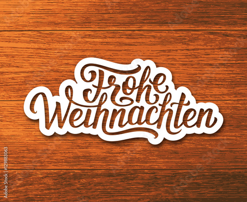 Frohe Weihnachten deutsch text on white paper label with hand lettering over wooden background. Merry Christmas sticker or greeting card vector design template with german inscription