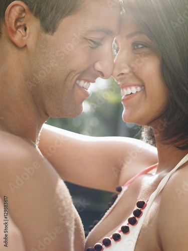 Side view of a happy young couple standing face to face photo