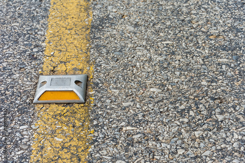 A reflector on the asphalt road.