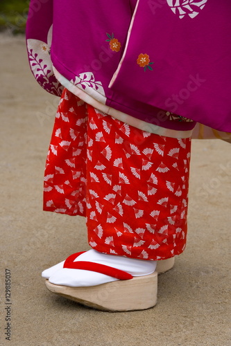 Woman wearing traditional Japanese kimono and okobo (tall wooden shoes), Kyoto, Kansai region, island of Honshu, Japan photo