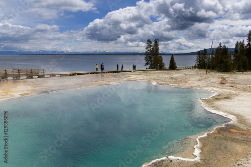 Steaming aqua hot spring, Yellowstone.  / Clear, aqua hot spring with deep central hole, steam and limy shoreline.