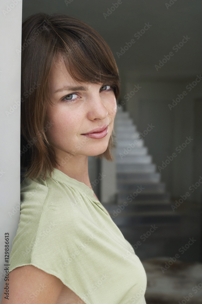 Portrait of a beautiful woman leaning on wall