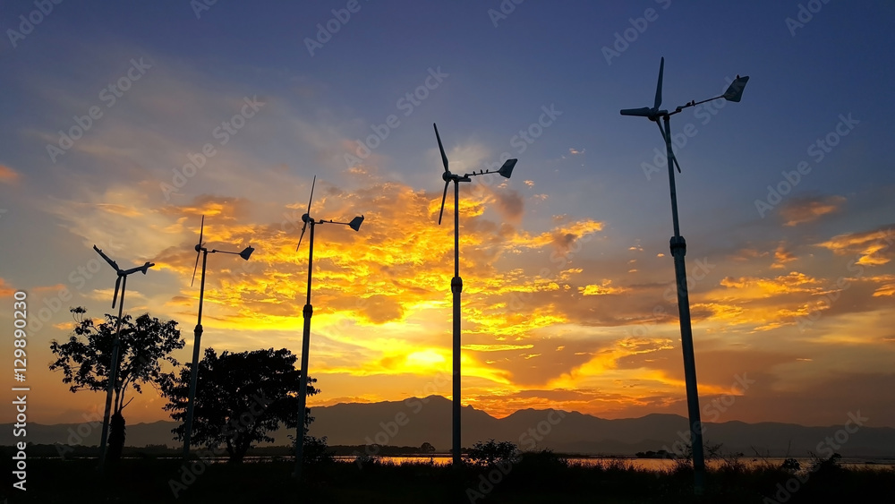 Obraz premium silhouette wind turbine on the sunset background.