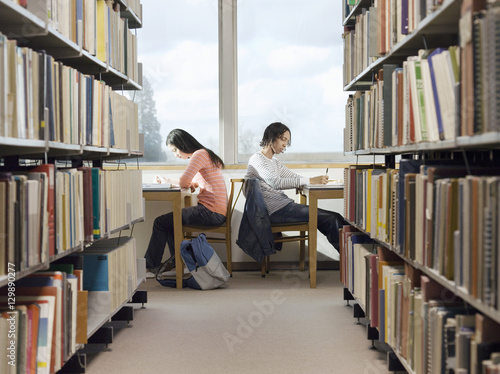 Side view of male and female students doing homework in the library 