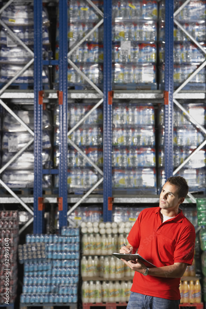 Young warehouse worker checking inventory Young warehouse worker checking inventory