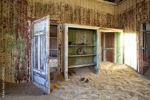 Interior of building slowly being consumed by the sands of the Namib Desert in the abandoned former German diamond mining town of Kolmanskop, Forbidden Diamond Area near Luderitz, Namibia  photo
