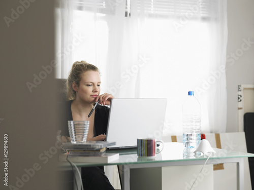 Young woman using laptop in home office