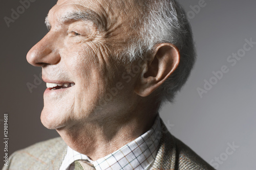 Foto Closeup of a smiling senior man against gray background