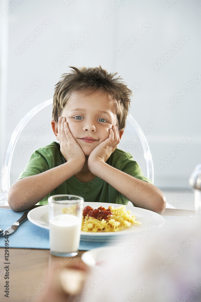 Portrait of bored young boy sitting at breakfast table Portrait of bored young boy sitting at breakfast table