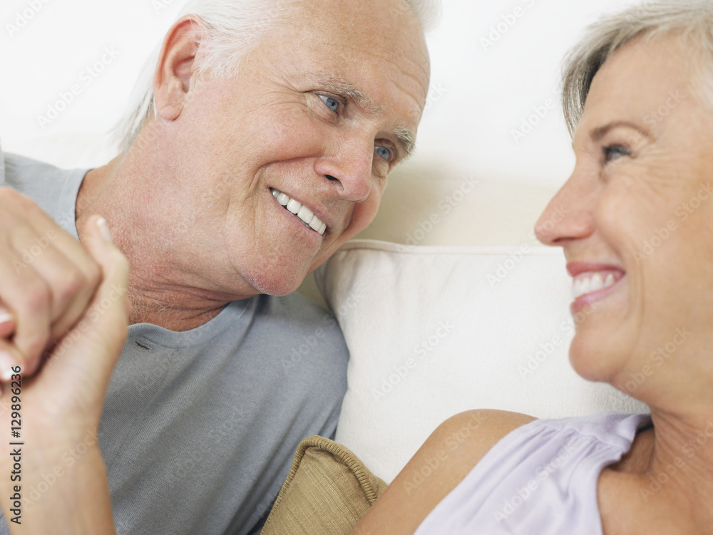 Closeup of a middle aged couple holding hands in bed Closeup of a middle aged couple holding hands in bed