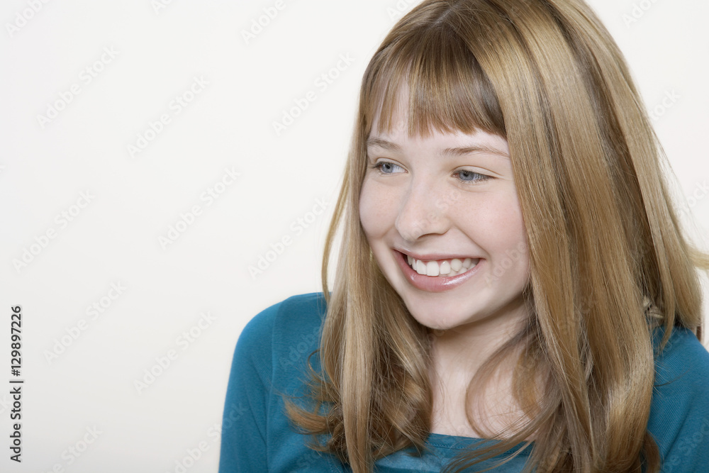 Closeup of a happy teenage girl looking at copyspace over white background Closeup of a happy teenage girl looking at copyspace over white background