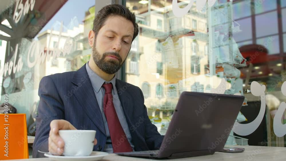 businessman at work and drinking coffee: working in a cafeteria with laptop businessman at work and drinking coffee: working in a cafeteria with laptop