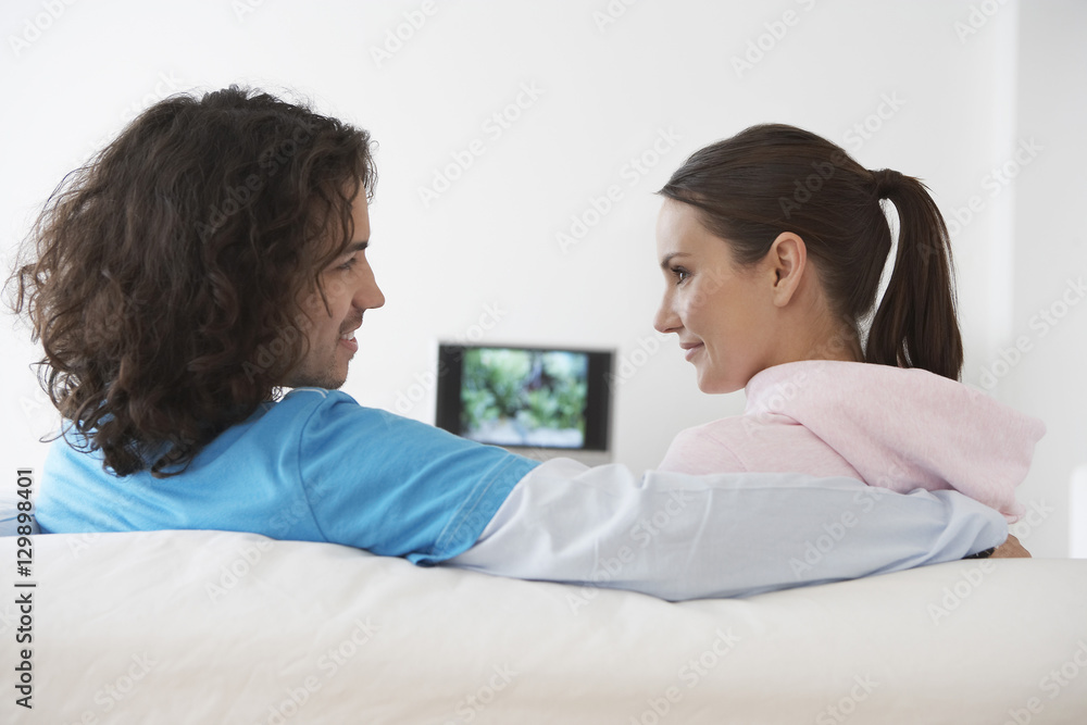 Closeup side view of a loving couple sitting on sofa Closeup side view of a loving couple sitting on sofa