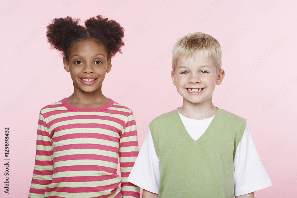 Portrait of African American girl with Caucasian boy against pink background Portrait of African American girl with Caucasian boy against pink background