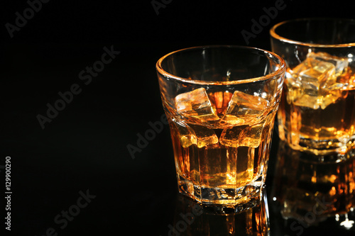 Glasses of whisky on dark background