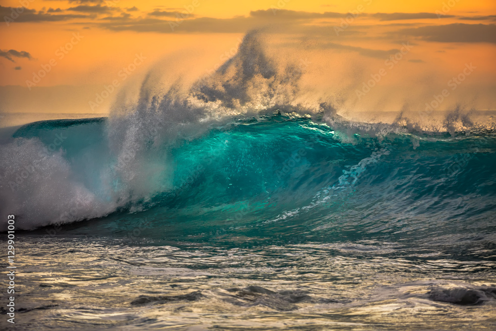 Green blue ocean splashing wave in front of orange sunset sky background - obrazy, fototapety, plakaty 