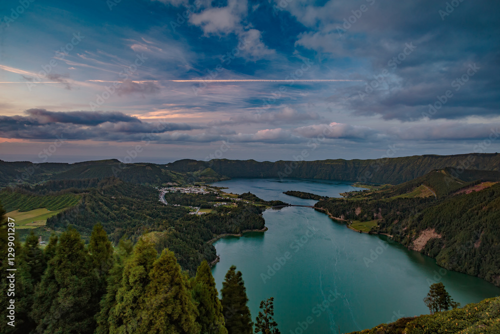 Obraz premium Mountain landscape in green valley with green lake in Azores island mountains with beautiful clouds at sunset time