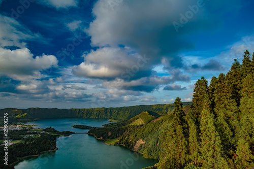 Mountain landscape in green valley with green lake in Azores island mountains with beautiful clouds at sunset time