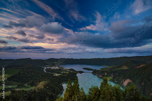 Mountain landscape in green valley with green lake in Azores island mountains with beautiful clouds at sunset time