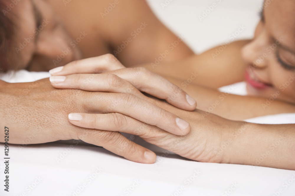 Closeup of affectionate couple holding hands in bed Closeup of affectionate couple holding hands in bed