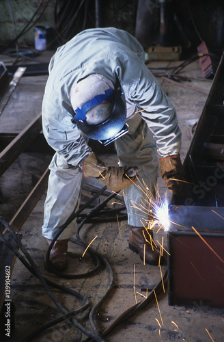 Welder bending down welding at Work