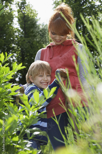 Portrait of smiling woman embracing son in the garden