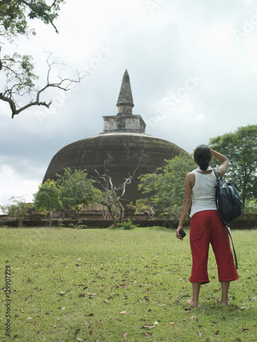 Full length rear view of a young female tourist looking at stupa