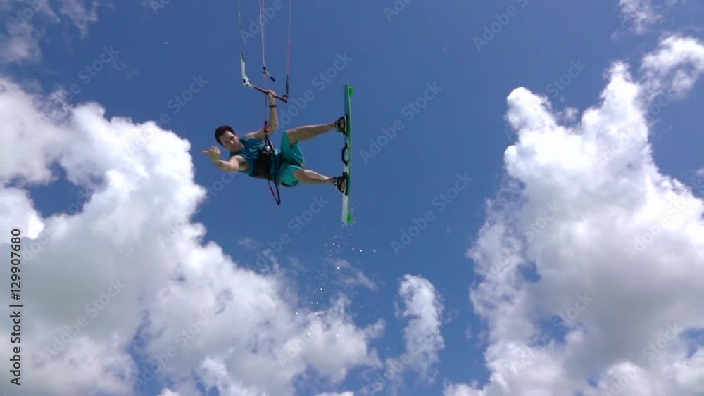 SLOW MOTION: Extreme kite boarder jumping high over the camera SLOW MOTION: Extreme kite boarder jumping high over the camera