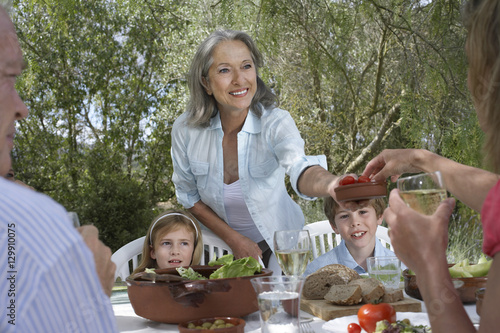 Three generation family eating at garden table