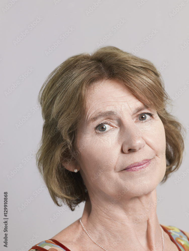 Closeup portrait of senior woman isolated on grey background