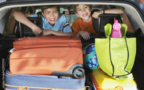 Portrait of smiling young boys in loaded car