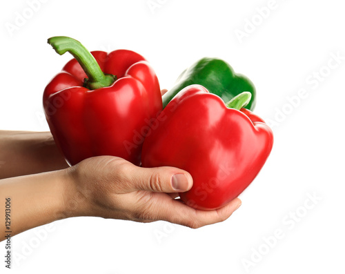 Human hands holding ripe bell pepper on white background