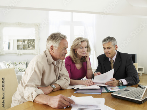 Mature couple sitting at table with financial advisor