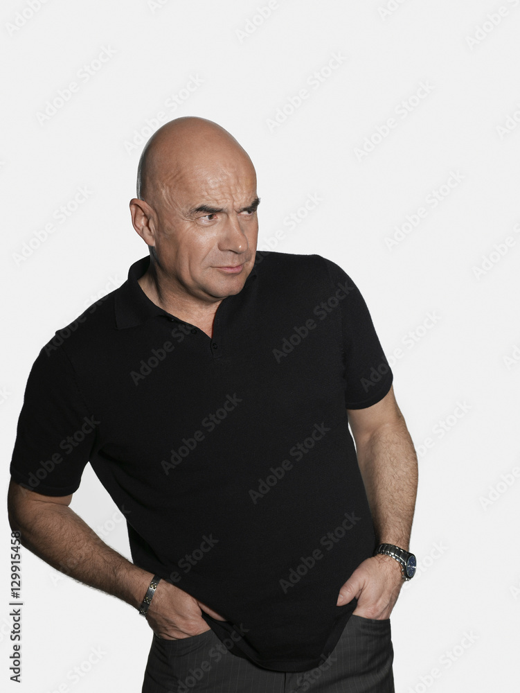 Suspicious middle aged man with hands in pockets looking away on white background Suspicious middle aged man with hands in pockets looking away on white background
