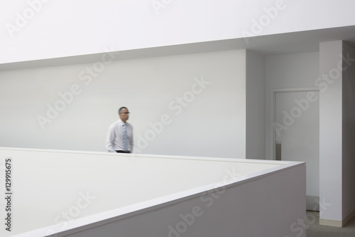 Side view of a businessman walking through office hallway