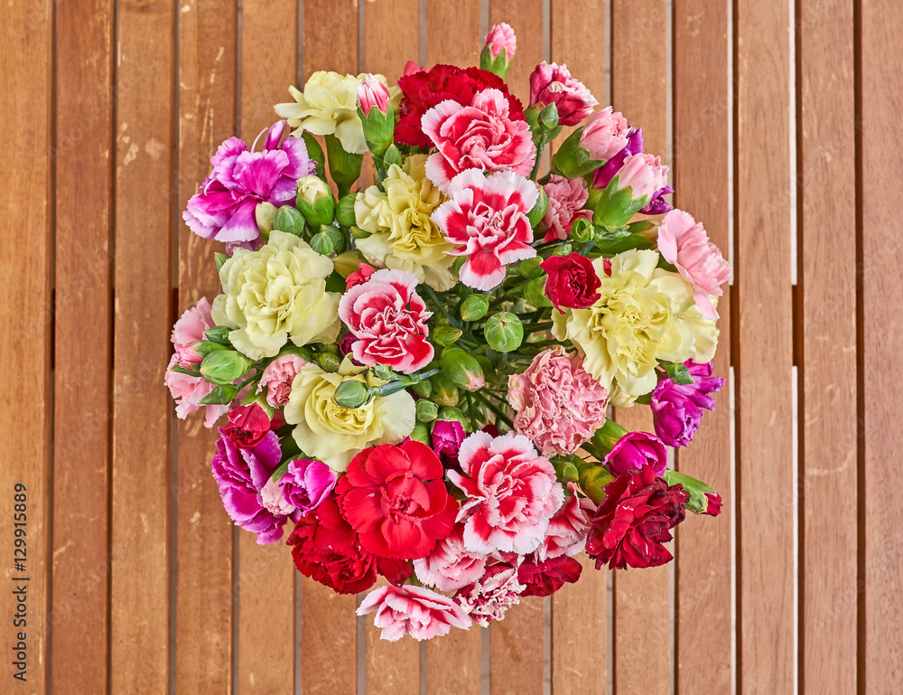 colorful carnation flowers bouquet on wooden background